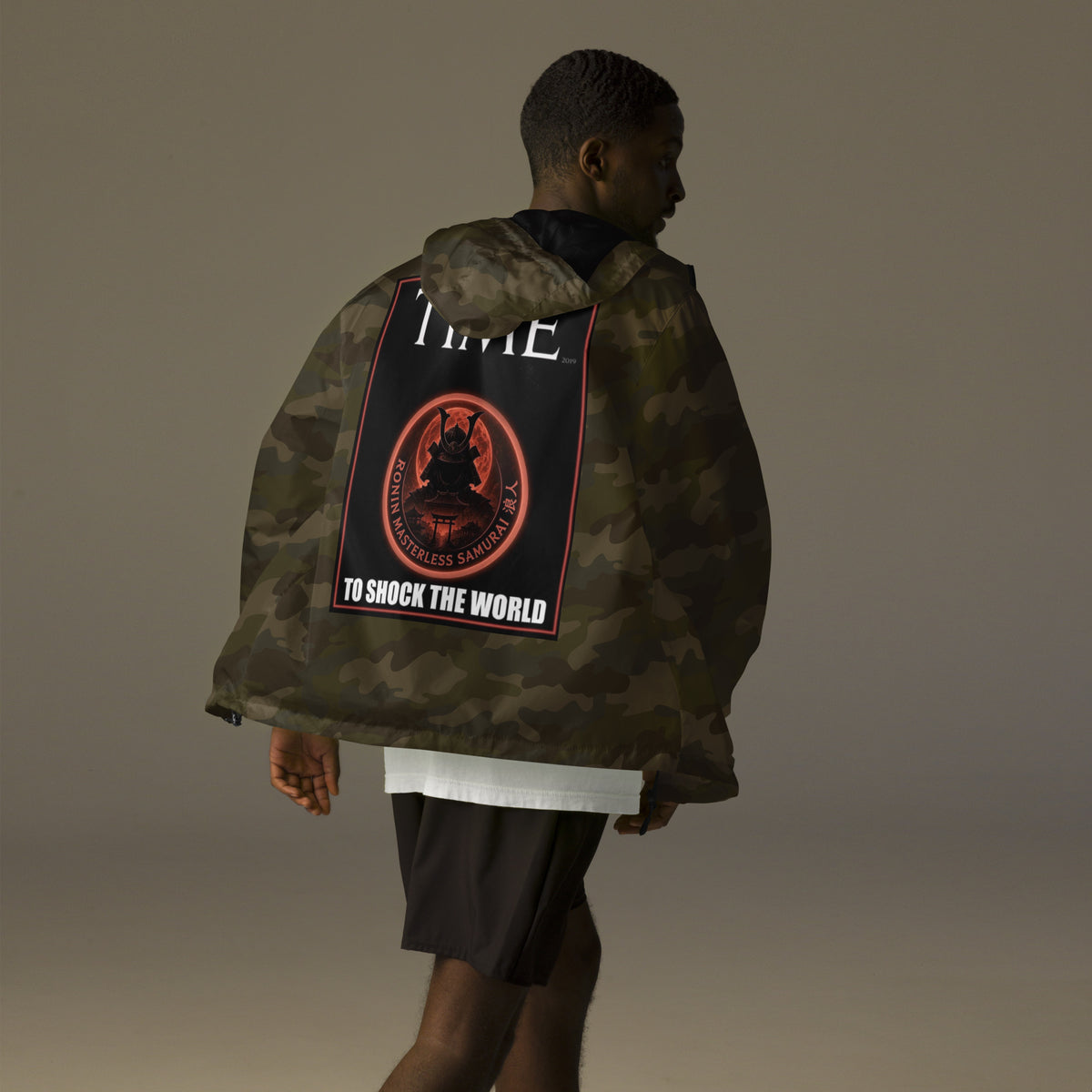 Ronin Cover Story Windbreaker, forest camo back: back print of a red-framed cover-style poster with the round RONIN samurai seal and TO SHOCK THE WORLD