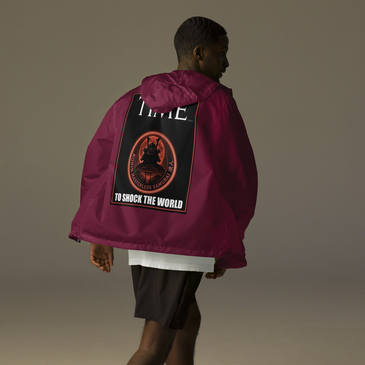 Ronin Cover Story Windbreaker, maroon back: back print of a red-framed cover-style poster with the round RONIN samurai seal and TO SHOCK THE WORLD